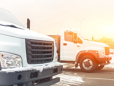 Two fleet vehicles with snow on the ground