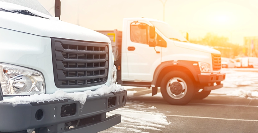 Two fleet vehicles with snow on the ground