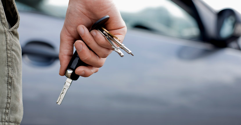 Person holding keys at their side walking to a vehicle