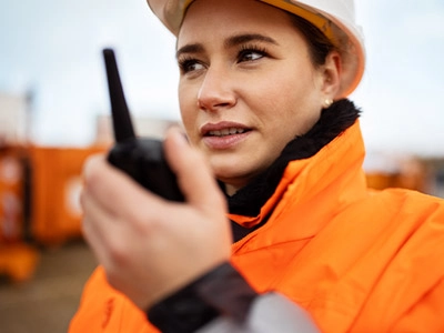 Construction worker using a walkie talkie