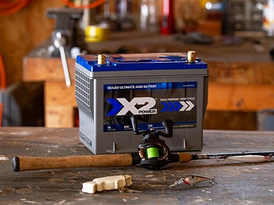 X2Power boat battery on a table with a fishing rod in front