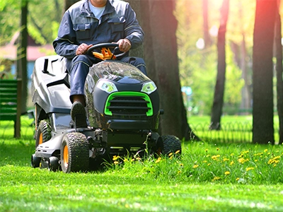 Riding lawn mower with trees in the back