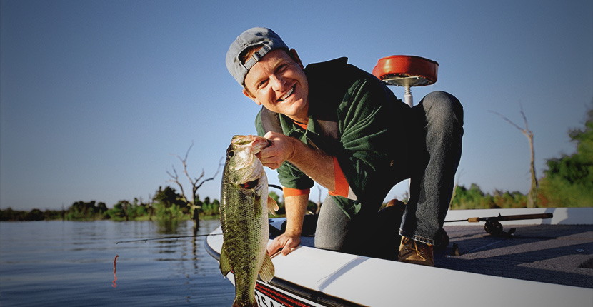 Angler in a boat holding a large fish