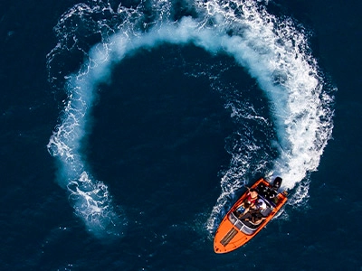 Overhead shot of an orange boat turning around