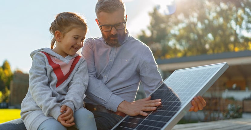 Father and daughter looking at a solar panel