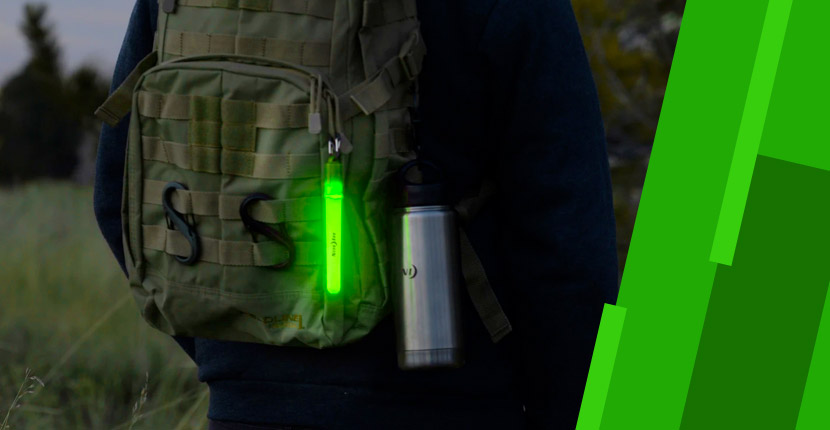 Person wearing a backpack with a water bottle and a glow stick
