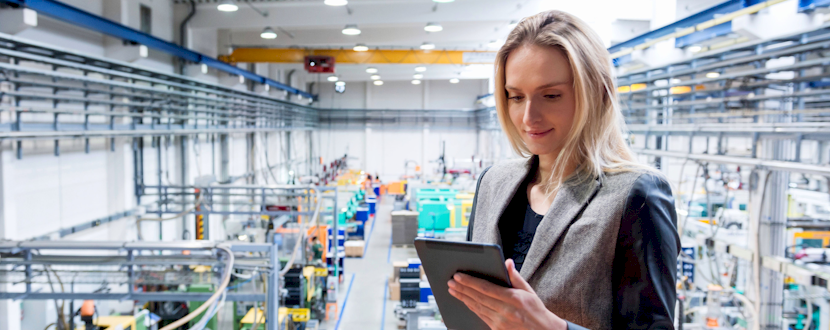 Female worker checking over the factory with a tablet