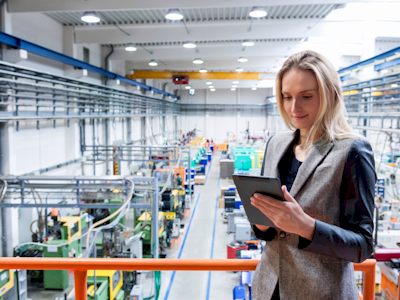 Female worker checking over the factory with a tablet