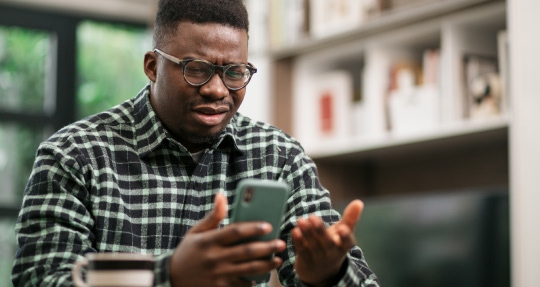 Man looking confused holding a phone