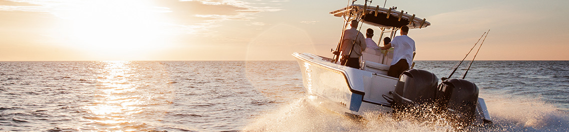 4 people on a large white boat driving towards the sun