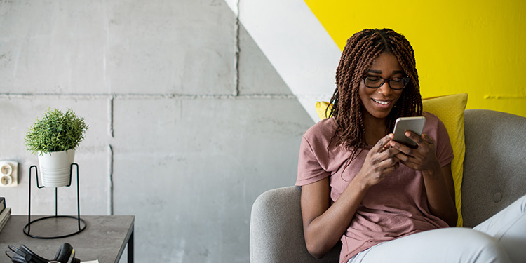 Woman sitting on a chair looking at her cell phone