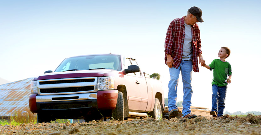 Father and sun standing in front of a truck