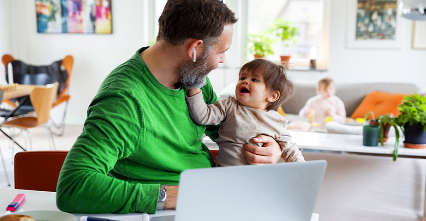 Father with child sitting by a laptop