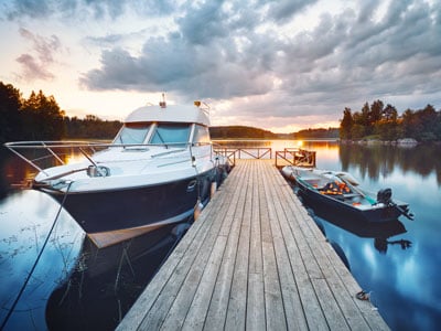 large black and white boat and small black boat tied up to a dock