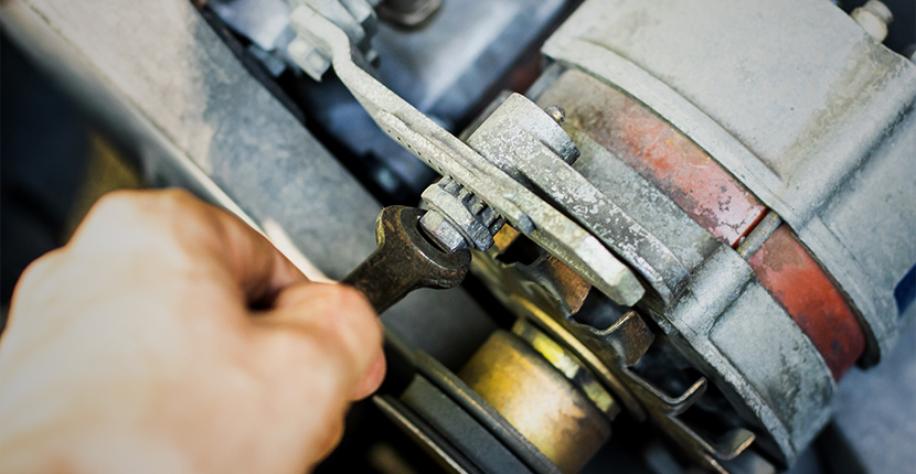 Using a wrench to remove a starter