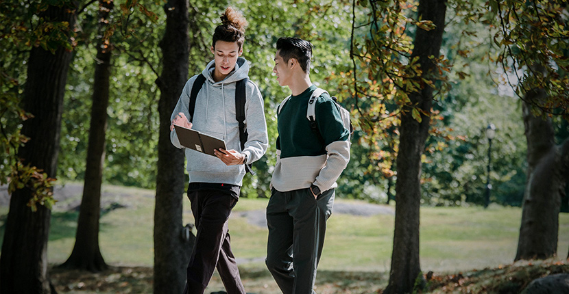 2 kids walking on a path with trees behind them