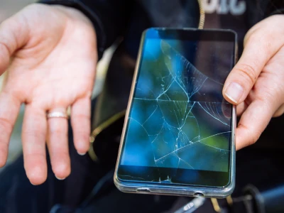 Holding a phone with cracked screen