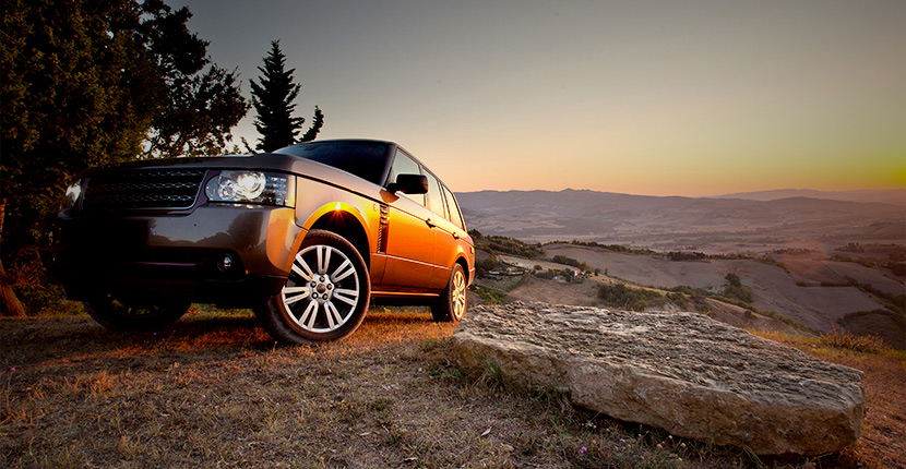 An SUV on rocky terrain at dusk