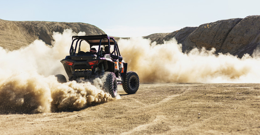 Driving an UTV in the dirt kicking up dust