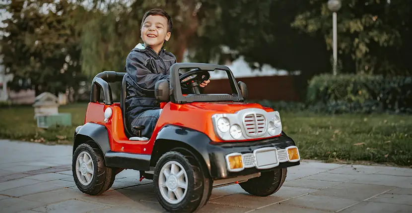 little boy riding in a red riding toy