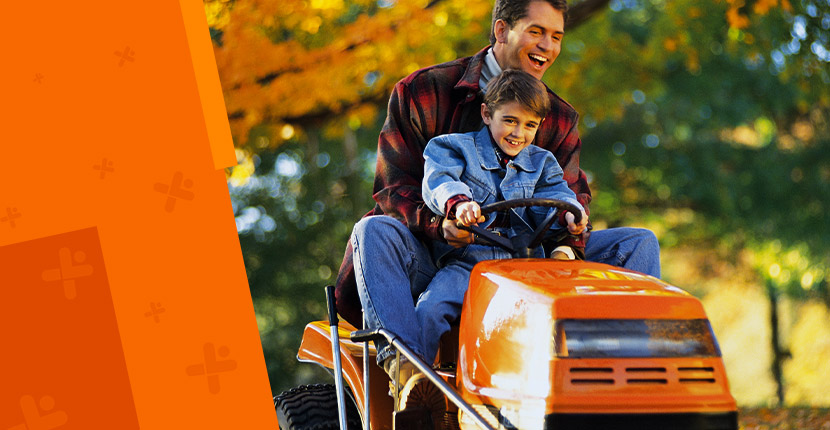 Father and son on an orange riding mower