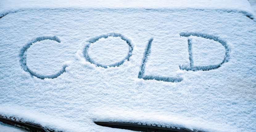 Snow covered windshield with COLD written in it