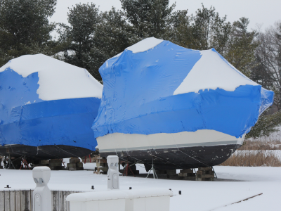 Boats in storage with snow on the covers