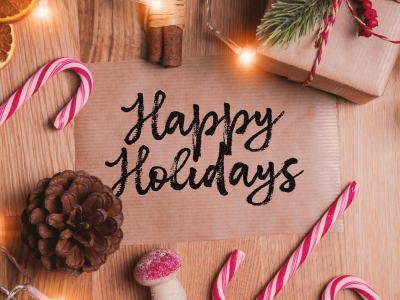 Happy Holidays written on paper with holiday themed items around it