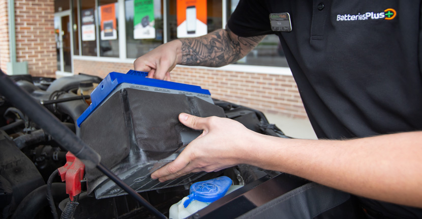 Employee replacing a battery before winter